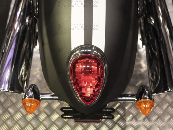 Black motorbike with red tail light and white stripes on metal floor, dortmund, deutchland