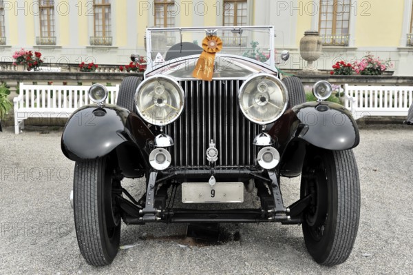Black classic vintage car with red ribbon, elegant in front of flower bed, Retro Classics meets