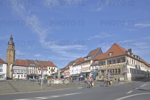 Market square with historic Schlundhaus, cyclist, steeple of the Church of the Assumption of the