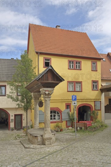 Historic council fountain built in 1583, draw well with columns and roof, house, Ochsenfurt, Lower