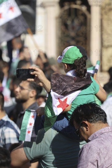 Thousands of Syrians march in Idlib carrying the Syrian revolutionary flag during a protest against