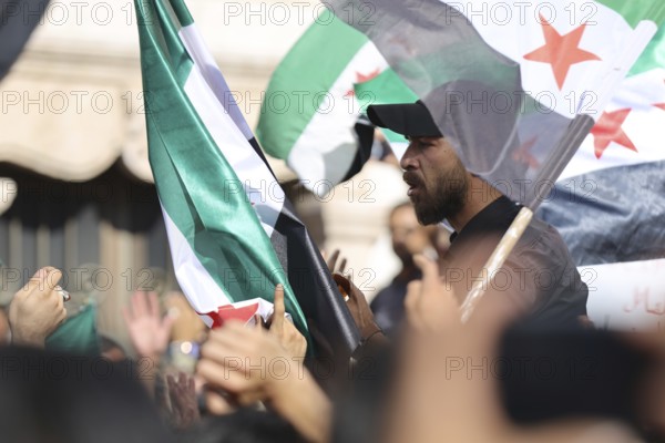 Thousands of Syrians march in Idlib carrying the Syrian revolutionary flag during a protest against