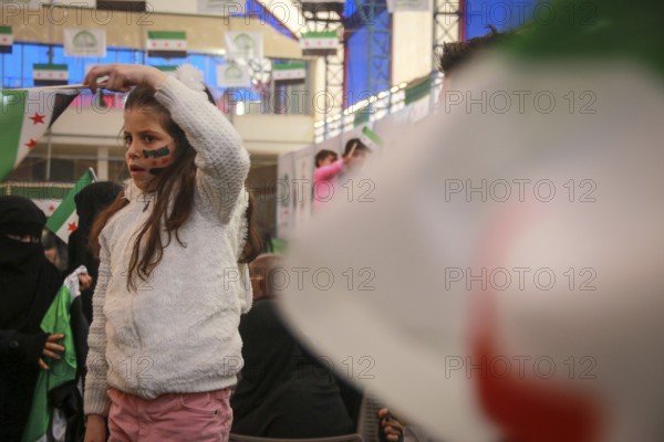 Syrians are seen demonstrating against the rule of Bashar al-Assad while carrying banners and the