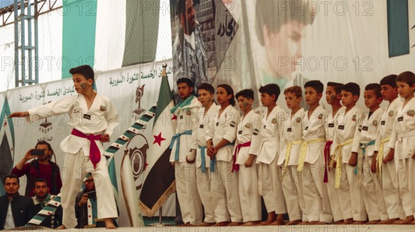 Syrians are seen demonstrating against the rule of Bashar al-Assad while carrying banners and the