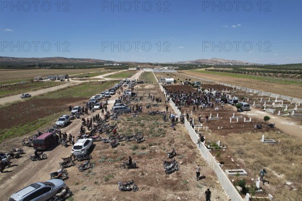 Thousands of Syrians march in Idlib carrying the Syrian revolutionary flag during a protest against
