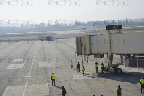 Syrians gather to welcome the first passenger plane to land at Aleppo International Airport