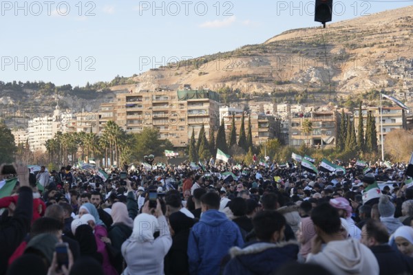 Thousands of Syrians take to public squares and main streets waving the revolutionary flag and