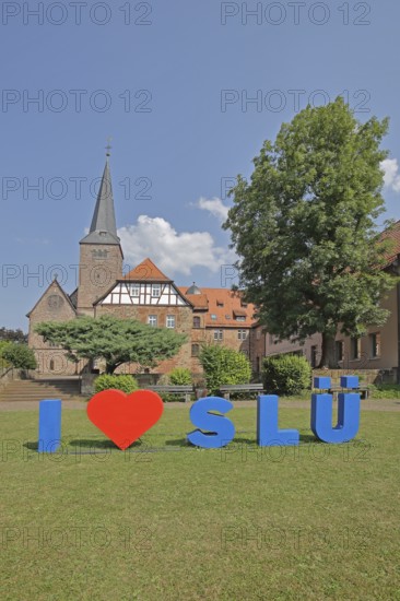 Heart sign as a symbol of solidarity and love for the city of SLÜ, monastery, church tower,