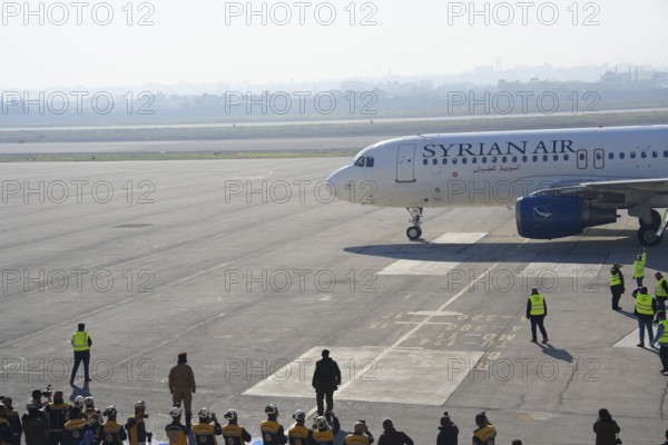 Syrians gather to welcome the first passenger plane to land at Aleppo International Airport