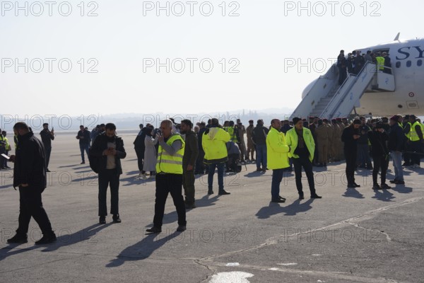 Passengers celebrate with Syrian revolutionary flags as the first flight lands at Aleppo