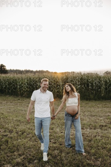 Pregnant young woman walks with her partner
