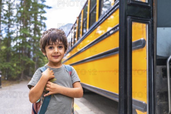 Elementary school student waiting at a mountain road, carrying a backpack and anticipating the