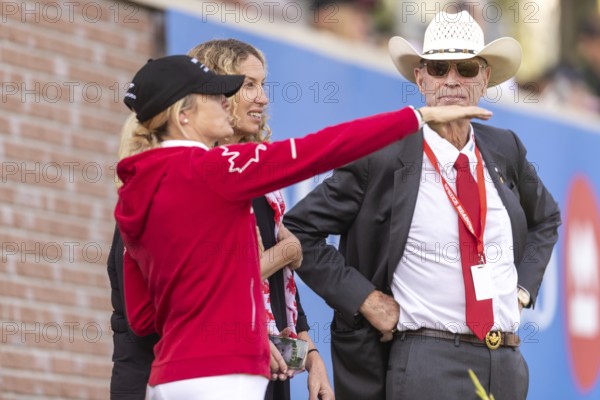Tiffany Foster, Amy Millar and Chef d'Equipe, Ian Millar from Team Canada watch Susan Horn compete