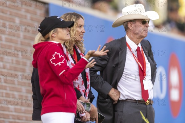 Tiffany Foster, Amy Millar and Chef d'Equipe, Ian Millar from Team Canada watch Susan Horn compete