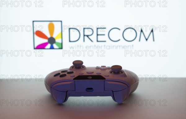 Dhaka, Bangladesh- 13 Sep 2025: A close-up of a white gamepad with the Drecom seen on screen in the