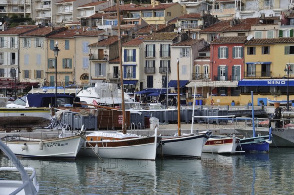 Cassis, the port, Boats docked in a harbor with colorful buildings lining the waterfront on an