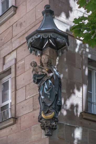 House saint, Mary with the baby Jesus under a canopy, at a residential and commercial building,