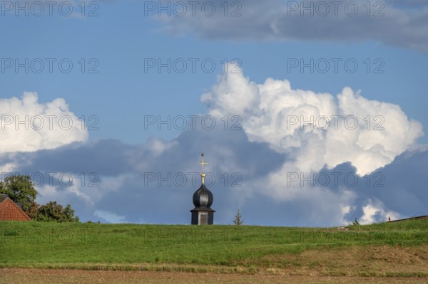 Tower of a chapel behind a meadow hill, cloudy sky, Köttweinsdorf, Upper Franconia, Bavaria,