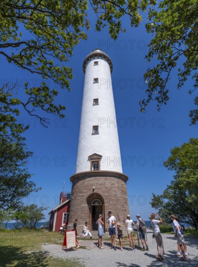 Tourists stand in front of the Lange Erik lighthouse, Langer Erik, on the northern tip of the