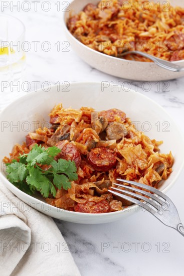 Bigos, Polish dish bigos, on the table, pan with stewed meat, with cabbage, chorizo sausages,