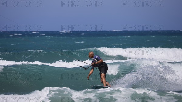Kitesurfer gliding over the waves in sunny weather and blue sky, Prasonisi, beach, surf,