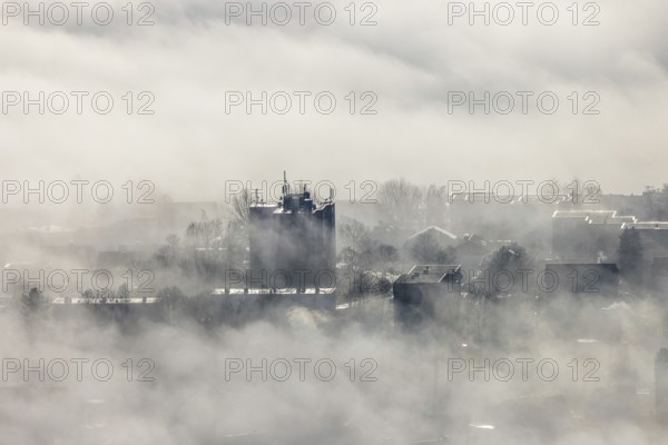 Aerial view, residential area in fog with high-rise building mobile phone antennas in backlight in