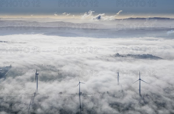 Aerial view, wind turbines in the fog and mountains of the Sauerland in the backlight in the