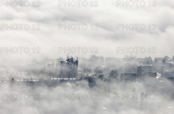 Aerial view, residential area in fog with high-rise building mobile phone antennas in backlight in