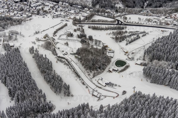 Aerial view of the snowy winter landscape of Winterberg with the St. Georg ski jump in the