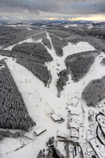 Aerial view of the snowy winter landscape of Winterberg with deserted ski lifts and slopes during