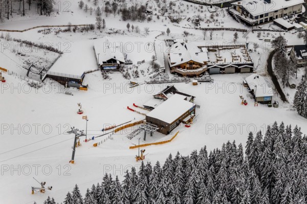 Aerial view of the snowy winter landscape of Winterberg with deserted ski lifts and slopes during