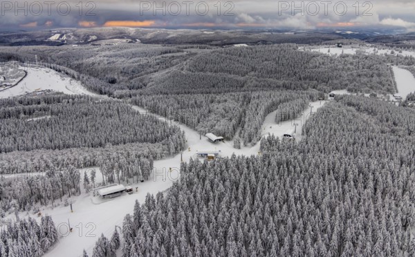 Aerial view of the snowy winter landscape of Winterberg with deserted ski lifts and slopes during
