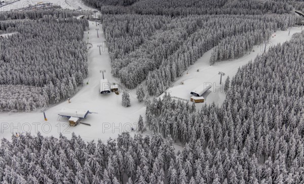 Aerial view of the snowy winter landscape of Winterberg with deserted ski lifts and slopes during