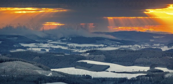 Aerial view of the sunset with a view over the snowy winter landscape from Winterberg to the