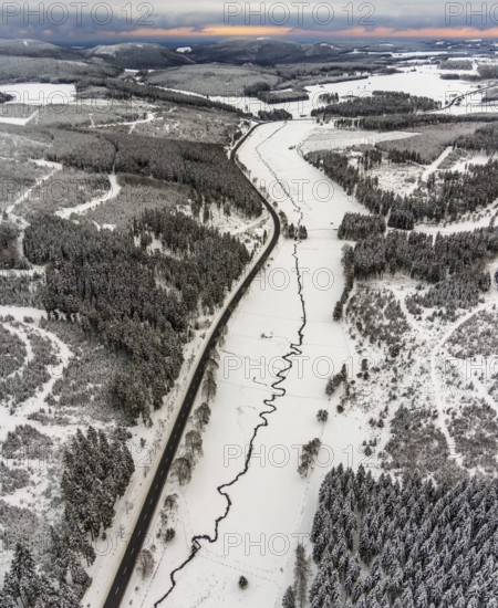 Aerial view of the Ruhr valley with the meandering Ruhr as a stream in the snowy winter landscape