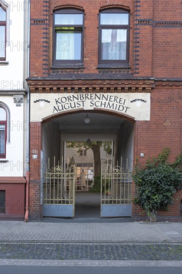 Photograph of the entrance to an old grain distillery with a wrought-iron golden Tor tor, Hainholz,
