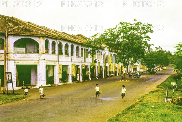 Row of Chinese shophouses businesses in building, unspecified location in Malaya, Malaysia, south