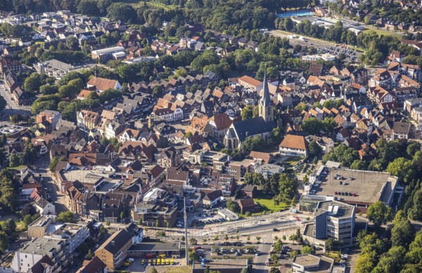 Close-up of the town centre with a prominent church surrounded by houses and green areas, aerial