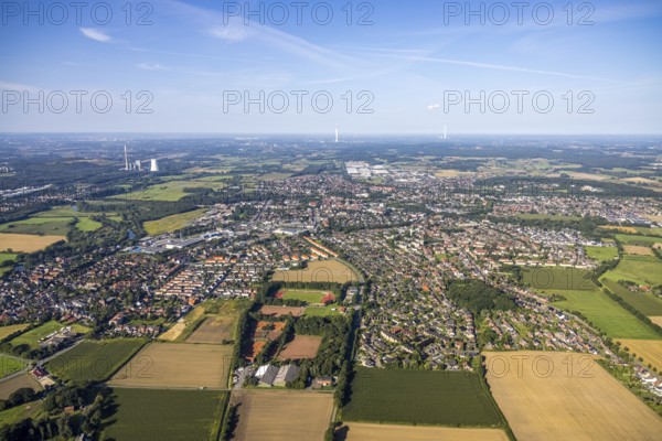 Aerial view of the city with numerous fields and houses under a slightly cloudy sky, aerial view