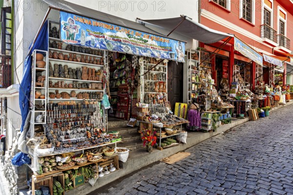 Steep street with shops selling pottery and souvenirs. Colourful facades create a nostalgic market