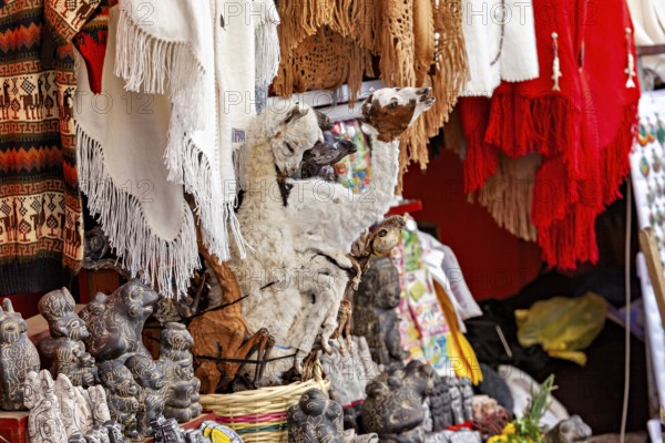 A market stall with a llama figure and colourful textiles represents Andean culture, The witches'