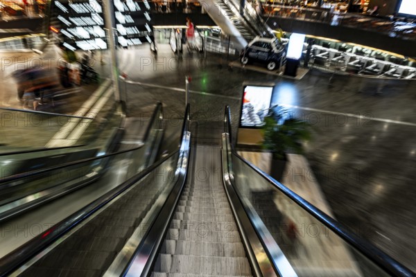 Inside Illuminated Zurich Airport with Escalator in Blurred Motion at Night in the Airport in