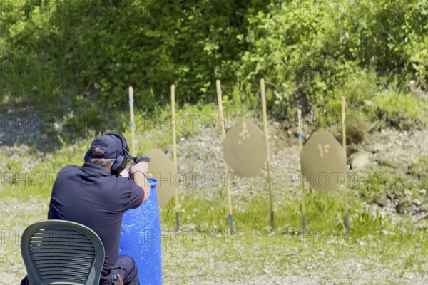 Man Sitting on a Chair and with Handgun and Holster Sport Training IPSC Shooting on an Outdoor