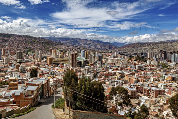 Panoramic view over La Paz with skyscrapers in front of a mountain landscape under a blue sky, The
