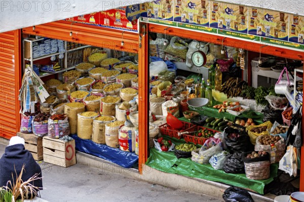 Lush market stall with different types of grain and traditional foods, small shops and restaurants