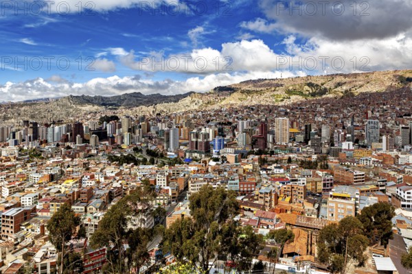 Cityscape with skyscrapers and cloudy sky in a mountain environment, The houses and skyscrapers of
