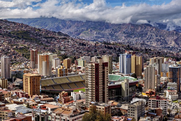 Panorama of La Paz with a view of skyscrapers and a stadium against a mountain backdrop, The houses