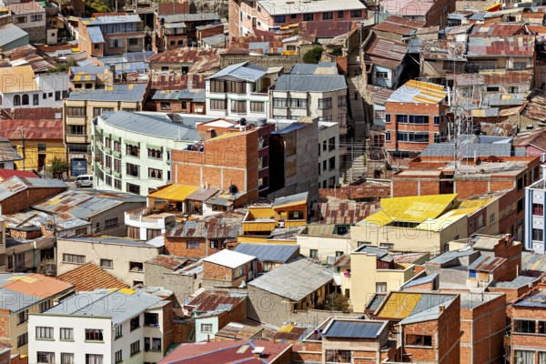 Densely packed urban cluster of houses with colourful roofs, The houses and skyscrapers of downtown