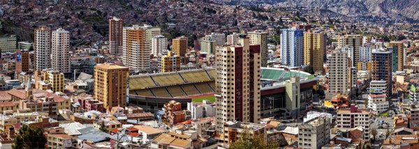 Urban scenery with stadium and skyscrapers in front of mountains, The houses and skyscrapers of the