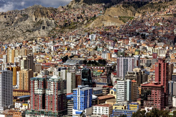 Densely built-up urban landscape with mountains in the background, The houses and skyscrapers of